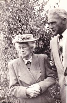 Len and Lil Rowe walking together outdoors in a garden setting, c.1950s–1960s
