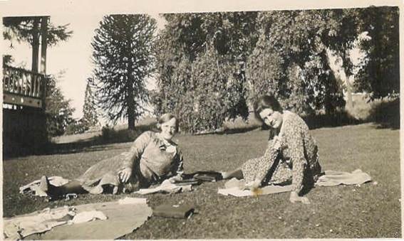 Two Robertson/Webber family women lying and sitting on a lawn in a garden, trees behind, c.1930s