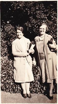 Evie Thompson (school teacher friend) and Mary Webber at Daylesford Gardens November 1930 — outdoor snapshot, two women standing against a leafy hedge, coats and handbags