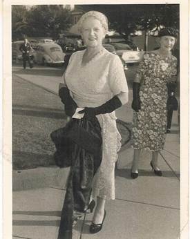 Mary Webber at St John's Church, Toorak at wedding of David & Judy Eakins 14 February — outdoor street snapshot, Mary in white lace dress