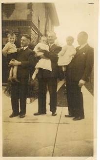 Robertson/Webber family — three men each holding a baby or toddler, standing on a footpath outside, c.1920s–1930s