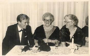 Robertson/Webber family — man in tuxedo seated at a formal dinner table with two women, candle on table, c.1960s