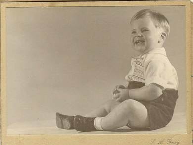 John Webber 1948 (19 months) — S. A. Gray — formal studio portrait, baby/toddler seated on floor in white shirt and dark shorts, big smile