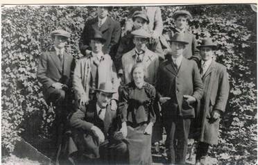 Group of about twelve Robertson/Webber family members outdoors against an ivy-covered wall — men and women in Edwardian/WWI-era clothing, c.1910s