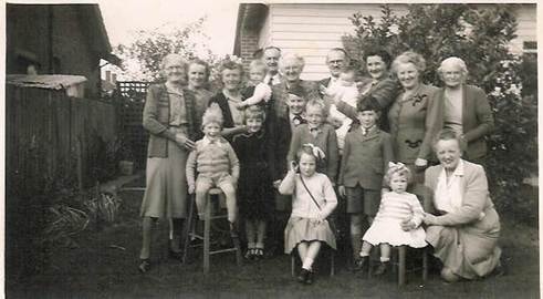 Robertson/Webber family — large group of about fourteen people including adults and children gathered outdoors in a garden, c.1950s–1960s