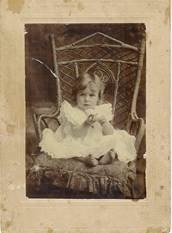 Beryl Bulte as baby/toddler in ornate wicker chair